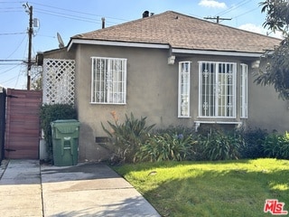 view of side of home featuring a yard and a patio area