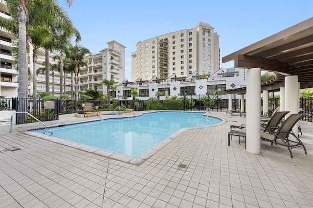 pool with a patio area and fence