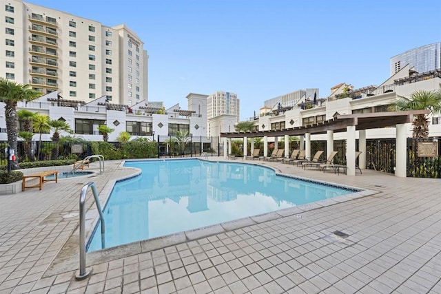 community pool with a patio area and fence