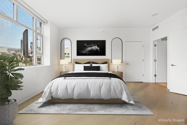 bedroom featuring visible vents and wood finished floors