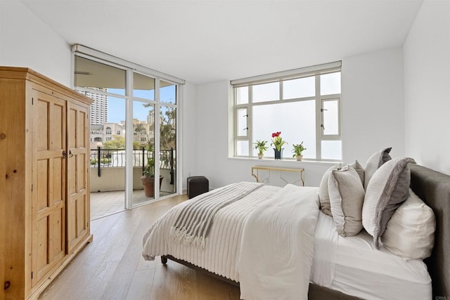 bedroom with access to exterior and light wood-type flooring