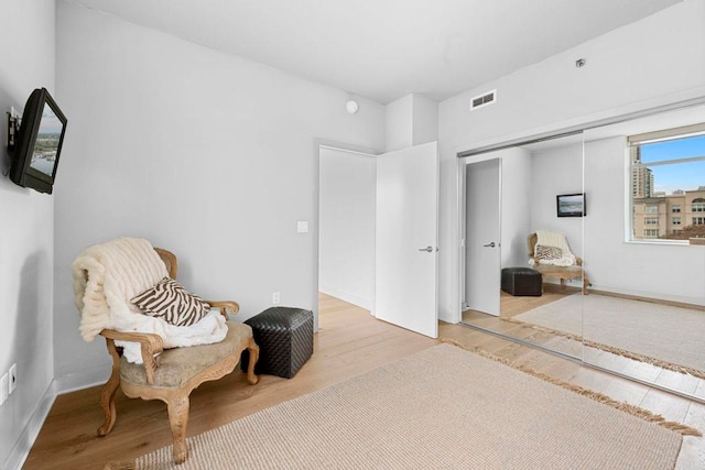 sitting room with visible vents and wood finished floors