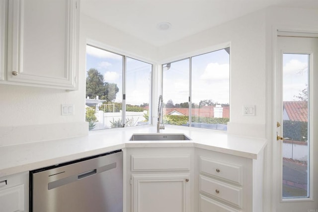 kitchen with dishwasher, sink, and white cabinets