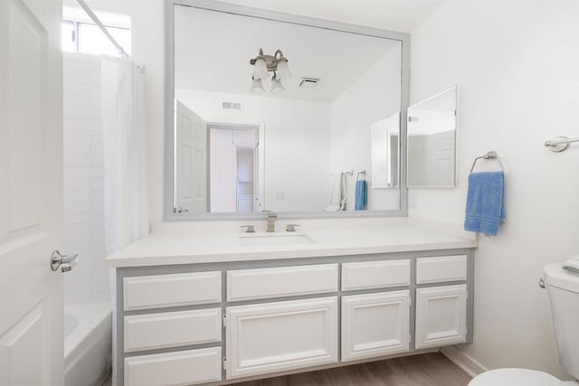 full bathroom with hardwood / wood-style flooring, vanity, shower / tub combo with curtain, and toilet