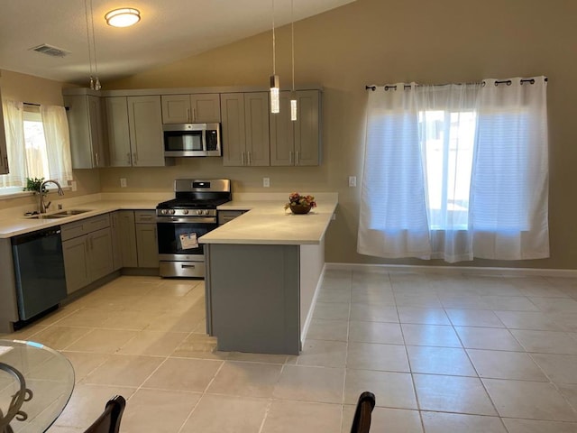 kitchen with sink, appliances with stainless steel finishes, hanging light fixtures, light tile patterned flooring, and kitchen peninsula