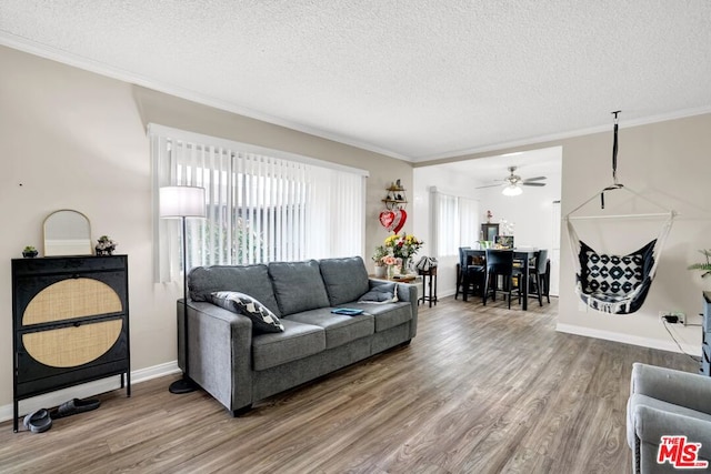 living room featuring a textured ceiling, wood-type flooring, and a healthy amount of sunlight