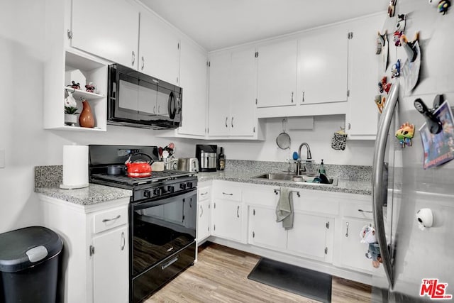 kitchen featuring white cabinetry, sink, and black appliances