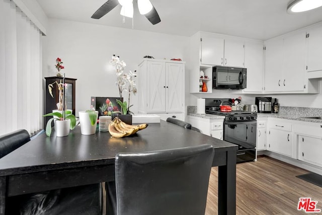 kitchen with white cabinetry, ceiling fan, dark hardwood / wood-style floors, and black appliances