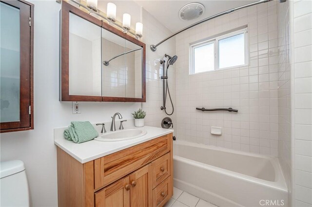 full bathroom with vanity, tile patterned flooring, tiled shower / bath combo, and toilet