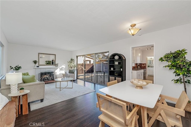 dining room with dark hardwood / wood-style floors and a fireplace