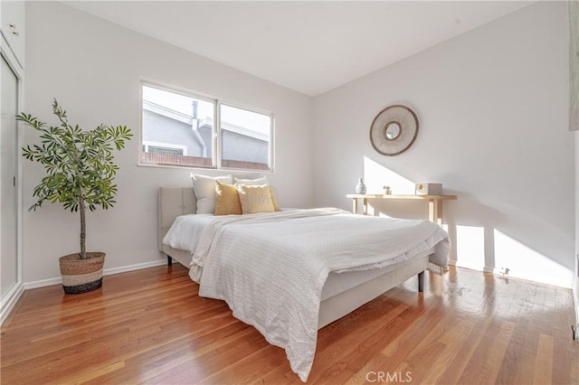 bedroom featuring light wood-style floors and baseboards