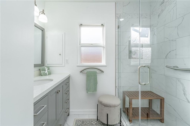 bathroom with a stall shower, marble finish floor, vanity, and baseboards