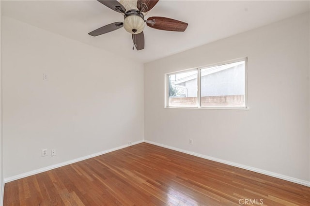 unfurnished room with a ceiling fan, baseboards, and wood finished floors