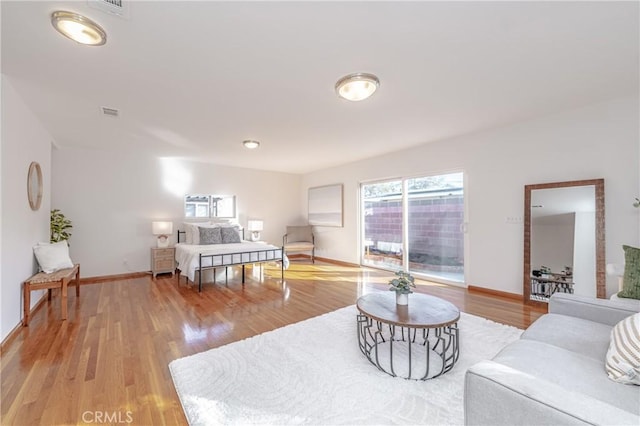 bedroom with visible vents, baseboards, and wood finished floors