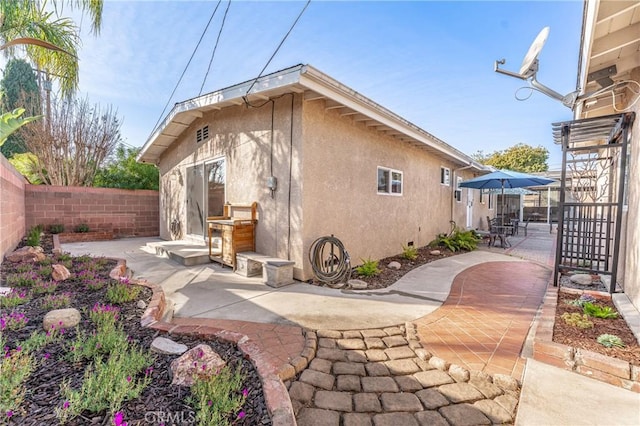 back of house featuring a patio area, a fenced backyard, and stucco siding