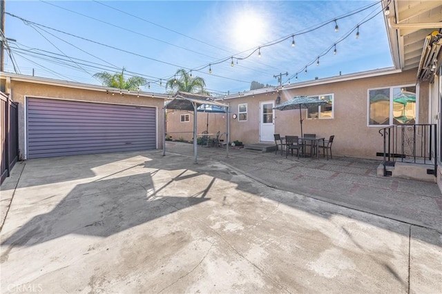 view of patio / terrace with entry steps, a garage, and an outbuilding