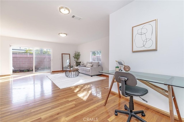 office space featuring wood finished floors, visible vents, and baseboards