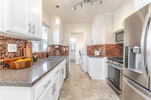 kitchen featuring sink, white cabinetry, dark stone countertops, stainless steel appliances, and decorative light fixtures