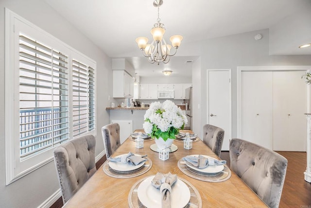 dining area with dark hardwood / wood-style flooring and a chandelier