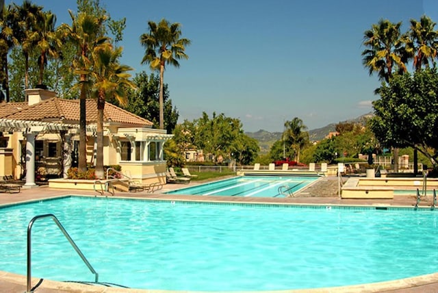 view of swimming pool featuring a mountain view and a patio area