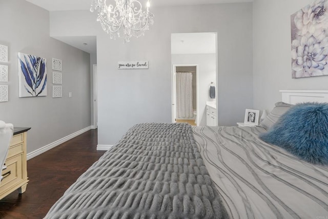 bedroom featuring dark wood-type flooring, connected bathroom, and a notable chandelier