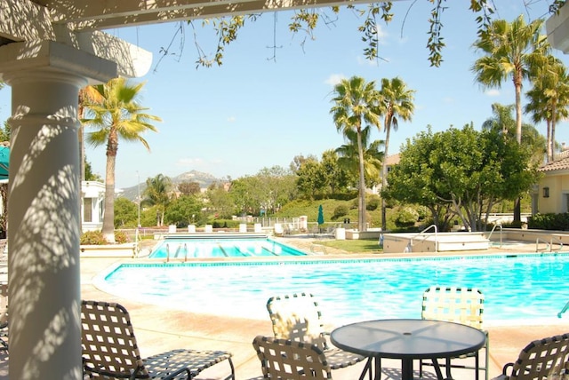 view of pool with a mountain view and a patio