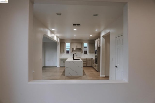 kitchen with tasteful backsplash, sink, double oven, and kitchen peninsula