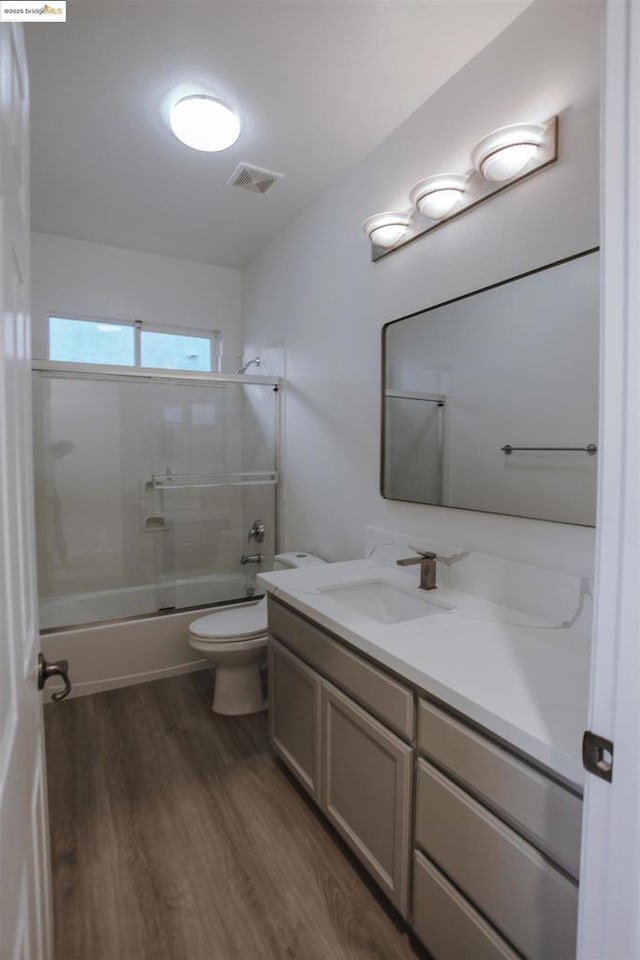 full bathroom featuring vanity, toilet, hardwood / wood-style floors, and shower / bathing tub combination