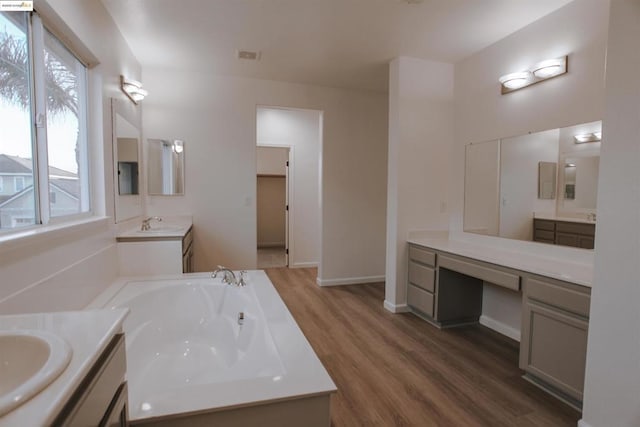 bathroom with plenty of natural light, a bath, hardwood / wood-style floors, and vanity