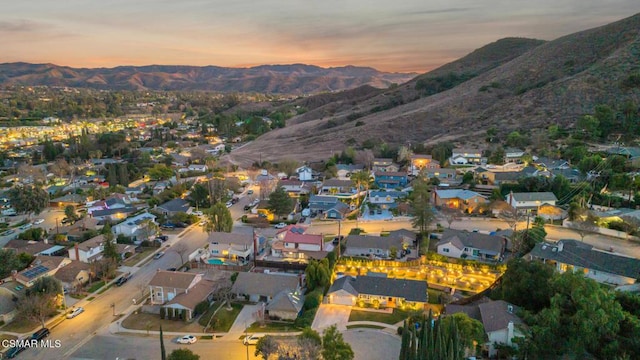 aerial view at dusk featuring a mountain view