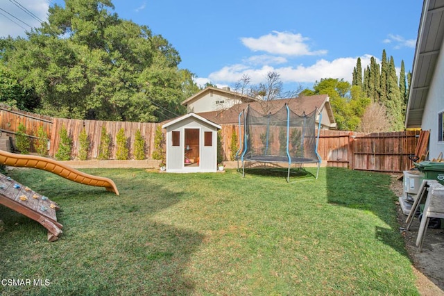 view of yard with a trampoline, a playground, and a storage unit