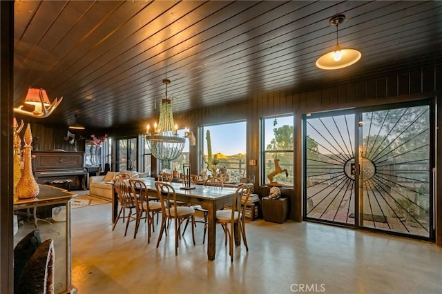 dining area with wood ceiling, a chandelier, and wood walls