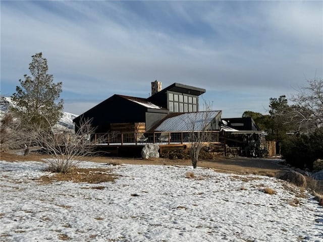 view of snow covered back of property