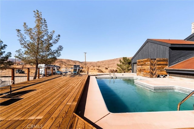 view of swimming pool featuring a deck with mountain view