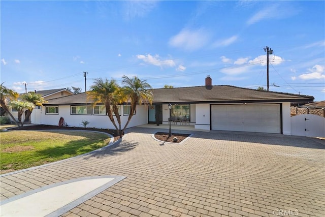 ranch-style house featuring a garage and a front lawn