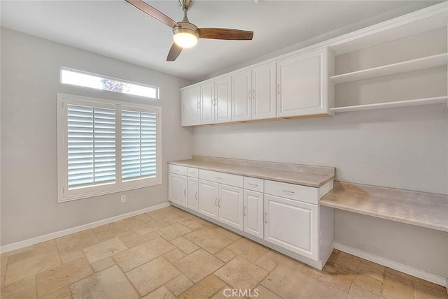 kitchen featuring a ceiling fan, baseboards, white cabinets, and light countertops