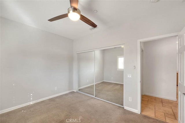 unfurnished bedroom featuring baseboards, visible vents, ceiling fan, carpet flooring, and a closet