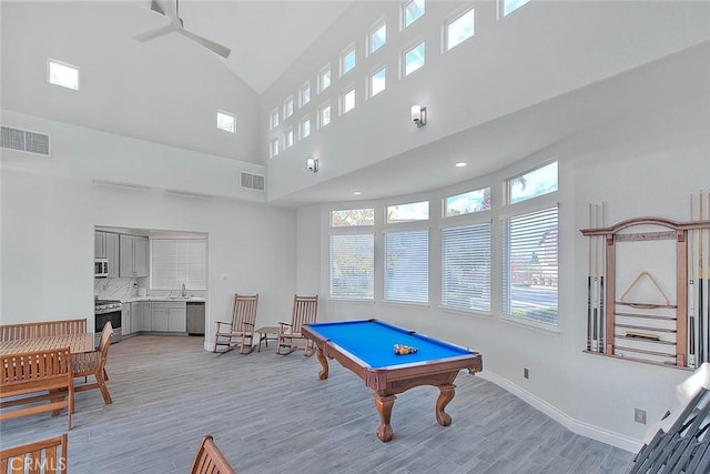 playroom with light wood-style flooring, a sink, visible vents, and baseboards