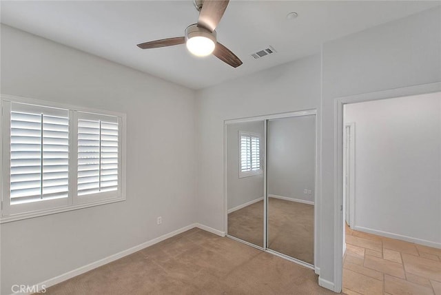 unfurnished bedroom featuring a ceiling fan, a closet, visible vents, and baseboards