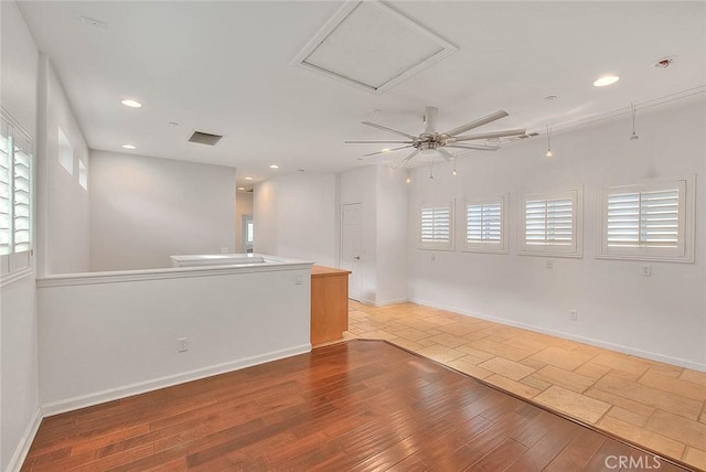 empty room featuring a healthy amount of sunlight, baseboards, wood finished floors, and recessed lighting