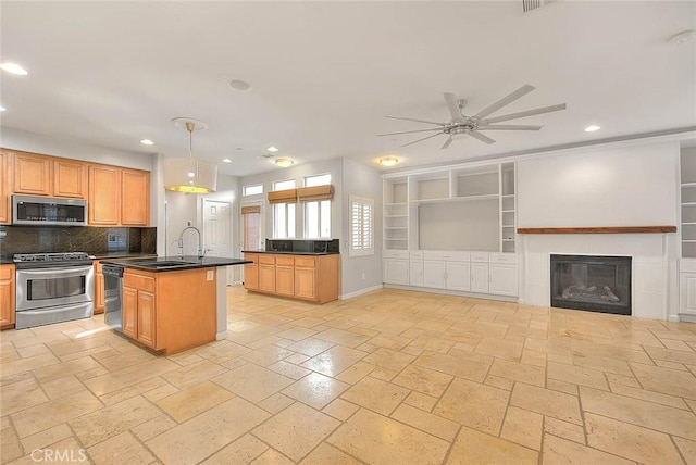 kitchen with dark countertops, appliances with stainless steel finishes, a sink, and recessed lighting