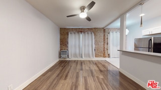 unfurnished living room featuring hardwood / wood-style flooring and ceiling fan