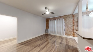 unfurnished living room with hardwood / wood-style flooring and ceiling fan