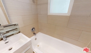 bathroom featuring vanity and tiled shower / bath combo