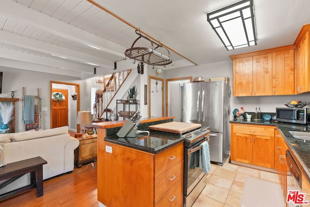 kitchen featuring wooden ceiling, dark stone countertops, a kitchen island, beamed ceiling, and stainless steel appliances