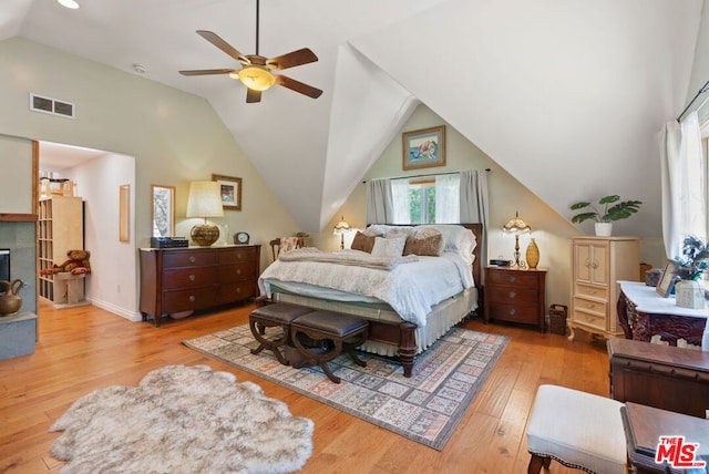 bedroom with ceiling fan, lofted ceiling, and light wood-type flooring