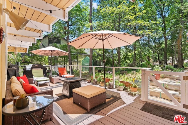 deck featuring an outdoor living space with a fire pit