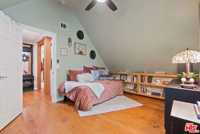 bedroom with hardwood / wood-style flooring, vaulted ceiling, and ceiling fan