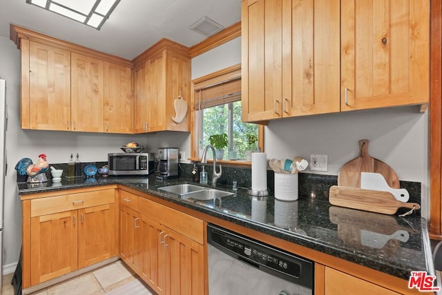 kitchen with appliances with stainless steel finishes, sink, and dark stone counters