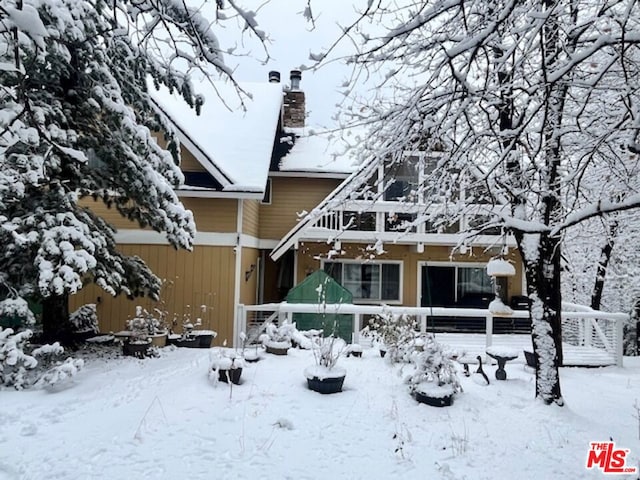 view of snow covered back of property